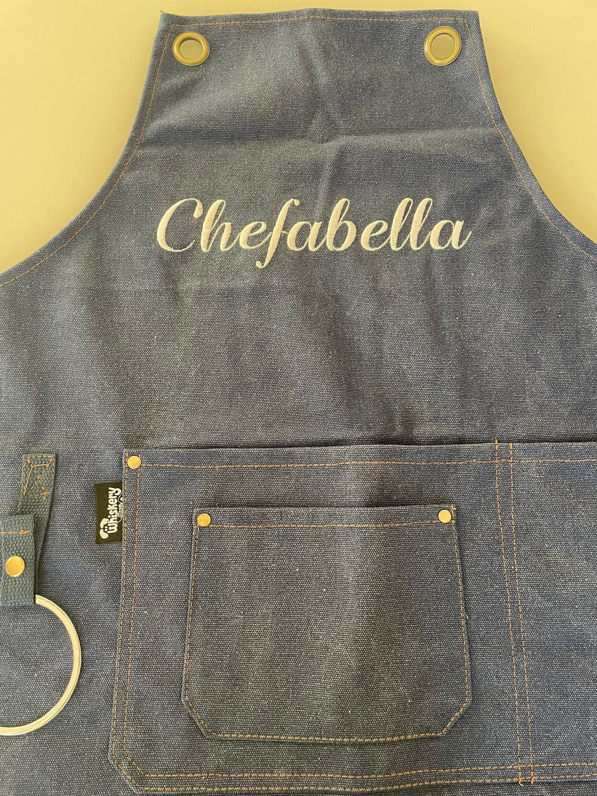 Grey canvas apron with Chefabella embroidered in gold script — personalised chef apron | Whiskery Sour